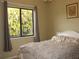A serene bedroom featuring a plush, white comforter and a window overlooking the garden at 406 Petrel Trl, Bradenton, FL 34212