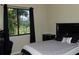 Bedroom with dark wood furniture and a view of lush landscaping through the window at 406 Petrel Trl, Bradenton, FL 34212