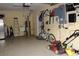 Organized garage with tools, ladders, bike, and lawnmower at 406 Petrel Trl, Bradenton, FL 34212