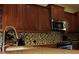 Contemporary kitchen featuring stainless steel appliances, stylish backsplash, and ample cabinet space at 406 Petrel Trl, Bradenton, FL 34212