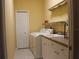 Functional laundry room with a washer, dryer, sink, and storage cabinets at 406 Petrel Trl, Bradenton, FL 34212