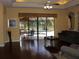 Bright living room featuring wood floors, neutral walls, and a view of the screened outdoor pool area at 406 Petrel Trl, Bradenton, FL 34212