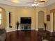 Spacious living room featuring wood floors, neutral walls and a tray ceiling with fan at 406 Petrel Trl, Bradenton, FL 34212
