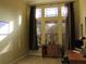 Comfortable home office with a workstation, cabinet, and large windows covered by dark curtains and wooden blinds at 406 Petrel Trl, Bradenton, FL 34212