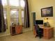 Inviting home office with a work desk, storage cabinet, and large windows for plenty of sunlight at 406 Petrel Trl, Bradenton, FL 34212