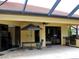 Spacious covered patio with an outdoor kitchen, grill, dining table, and ceiling fan at 406 Petrel Trl, Bradenton, FL 34212