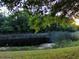 Scenic pond view with green vegetation, trees, and a hint of sunlight, creating a peaceful nature scene at 406 Petrel Trl, Bradenton, FL 34212