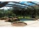Beautiful screened-in pool with a tranquil rock waterfall feature, spa, and serene backyard views at 406 Petrel Trl, Bradenton, FL 34212