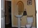 Powder room featuring an oval mirror, pedestal sink, and toilet at 406 Petrel Trl, Bradenton, FL 34212