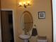 Bright powder room with a pedestal sink, toilet, and decorative mirror at 406 Petrel Trl, Bradenton, FL 34212