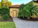Side entrance of home with brick pathway, lush landscaping, and a charming exterior light fixture at 406 Petrel Trl, Bradenton, FL 34212