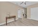 A bedroom with tiled floors and a console table, leading to the stairway and an open entryway at 4153 Camino Real, Sarasota, FL 34231