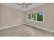 A bedroom with tiled floors, a ceiling fan, and a large window with outside views at 4153 Camino Real, Sarasota, FL 34231