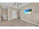A bedroom featuring tiled floors, a ceiling fan, a wall-mounted television and an open entryway at 4153 Camino Real, Sarasota, FL 34231