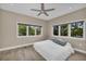 Bright bedroom features wood floor, ceiling fan and large windows with scenic outdoor views at 4153 Camino Real, Sarasota, FL 34231