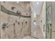 Walk-in shower with tiled walls, multiple shower heads, and glass door at 4153 Camino Real, Sarasota, FL 34231