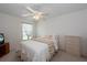 Comfortable bedroom with natural light, featuring a ceiling fan, a dresser, and a serene ambiance at 4219 Eastlake Ct, Port Charlotte, FL 33948