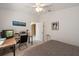Well-lit bedroom features a ceiling fan, neutral carpet, and a view leading into the attached bathroom at 4219 Eastlake Ct, Port Charlotte, FL 33948