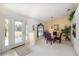 Bright dining area with glass table, purple chairs, and a view of the home's front entrance at 4219 Eastlake Ct, Port Charlotte, FL 33948