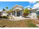 Charming single-story home with manicured landscaping, palm trees, and a welcoming columned front porch at 4219 Eastlake Ct, Port Charlotte, FL 33948