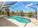 Screened-in kidney shaped pool with views of canal, landscaping and blue skies at 4219 Eastlake Ct, Port Charlotte, FL 33948