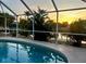 Screened-in pool at dusk, with tranquil water and view of the waterway at 4219 Eastlake Ct, Port Charlotte, FL 33948