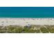 Aerial view showcasing beach with blue water and beachgoers enjoying the sun at 452 Picasso Dr, Nokomis, FL 34275