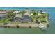 Waterfront home aerial view featuring screened pool, dock, and lush landscaping at 452 Picasso Dr, Nokomis, FL 34275