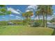 Expansive backyard featuring lush green lawn, mature palm trees, and stunning views of the canal at 452 Picasso Dr, Nokomis, FL 34275