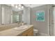 Bathroom featuring a sink with vanity, a toilet, a mirror, and a tiled walk-in shower with a window at 452 Picasso Dr, Nokomis, FL 34275