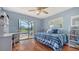 Well-lit bedroom with light blue walls, wood floors, bed and desk overlooking the pool at 452 Picasso Dr, Nokomis, FL 34275