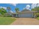 Inviting home with a spacious driveway, two-car garage, and lush green lawn at 452 Picasso Dr, Nokomis, FL 34275