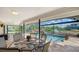 Inviting outdoor patio with a dining table, a partial view of the pool, and tranquil waterfront scenery at 452 Picasso Dr, Nokomis, FL 34275