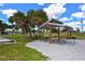 Outdoor picnic area with wooden tables and shady shelters surrounded by trees and greenery at 452 Picasso Dr, Nokomis, FL 34275