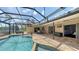 Spacious lanai with travertine flooring provides seamless access to a refreshing pool and outdoor entertainment area at 452 Picasso Dr, Nokomis, FL 34275