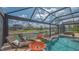Relaxing screened-in pool area with waterfall features, lounge chairs, and beautiful canal views at 452 Picasso Dr, Nokomis, FL 34275
