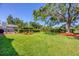 Expansive backyard featuring a well-manicured lawn, mature shade trees, and garden beds, perfect for outdoor enjoyment at 4806 Huntleigh Dr, Sarasota, FL 34233