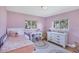 Pink bedroom with twin bed, large windows, rainbow themed décor and wood floors at 4806 Huntleigh Dr, Sarasota, FL 34233