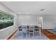 Dining room features a large window, hardwood floors, and a dark wood table with white chairs at 4806 Huntleigh Dr, Sarasota, FL 34233