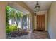 Inviting entryway with a decorative light and a tropical garden at 4806 Huntleigh Dr, Sarasota, FL 34233