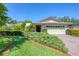 Home with mature landscaping and a brick paver driveway at 4806 Huntleigh Dr, Sarasota, FL 34233
