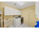 Laundry room with a washing machine, dryer, utility sink, and white cabinets at 4806 Huntleigh Dr, Sarasota, FL 34233