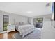 Large main bedroom with a large window, white furniture and access to the screened in patio at 4806 Huntleigh Dr, Sarasota, FL 34233