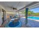 Covered patio with a ceiling fan, outdoor dining table and chairs overlooking the pool at 4806 Huntleigh Dr, Sarasota, FL 34233