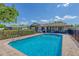 A backyard pool with beautiful, clear water and a paver deck is surrounded by a black fence with the home in the background at 4806 Huntleigh Dr, Sarasota, FL 34233