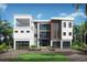 Modern three-story home featuring a clean white facade, a balcony, and two-car garage at 5210 Inspiration Ter, Bradenton, FL 34210