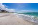Beautiful beach with gentle waves, clear skies, and nearby condos creating an inviting coastal setting at 535 Sanctuary Dr # A602, Longboat Key, FL 34228