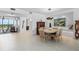 Open concept dining area with modern lighting fixture, tile flooring, and access to a bright sunroom at 535 Sanctuary Dr # A602, Longboat Key, FL 34228