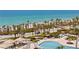 A bird's eye view of the sandy beaches, tropical foliage, and pool with umbrellas at 535 Sanctuary Dr # A602, Longboat Key, FL 34228