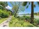 Lakeside path with vibrant greenery, palm trees and building exterior with beautiful water views at 5395 Lake Arrowhead Trl # 24, Sarasota, FL 34231